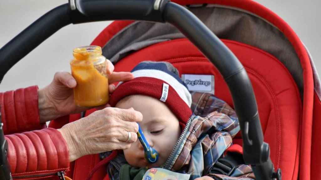 Un bebé comiendo en su carrito alimentación bio / BICANSKI (PIXNIO)