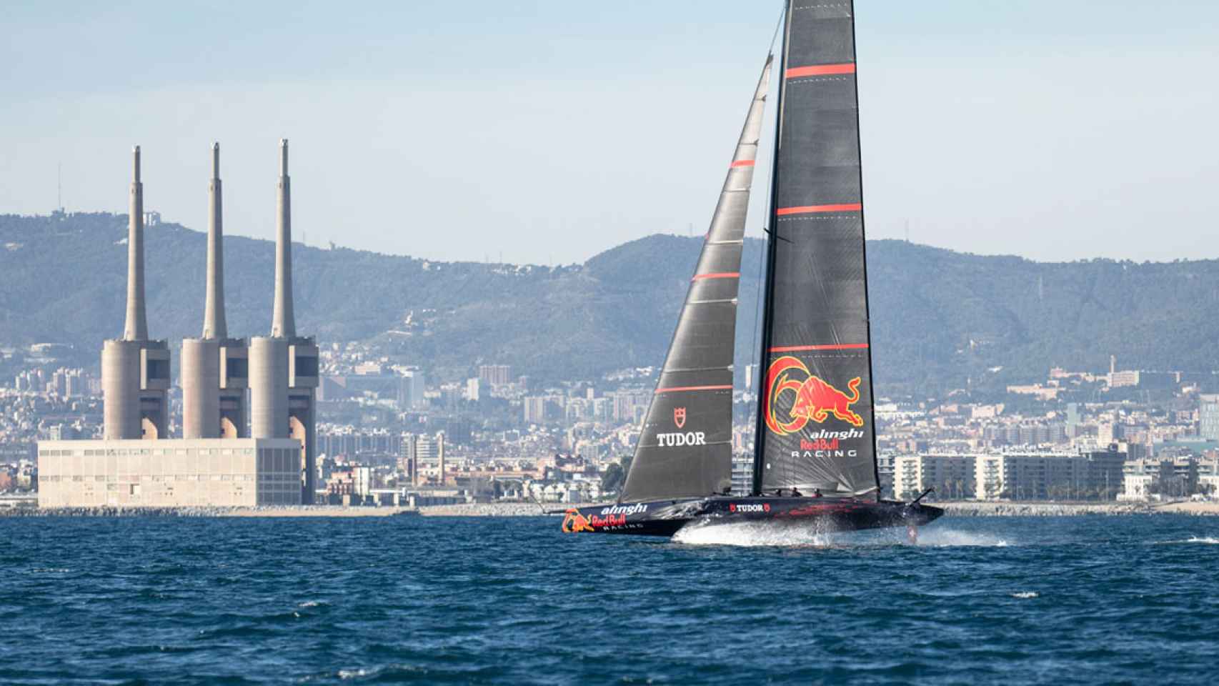 Un buque AC75 de la Copa América con las Tres Chimeneas del Besòs de fondo / Cedida