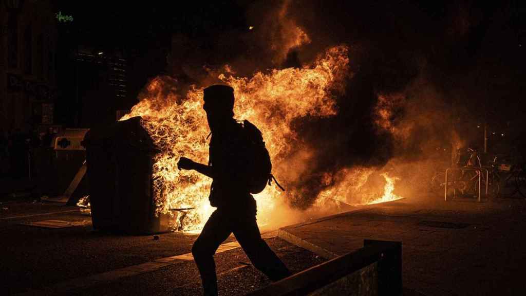 Un manifestante cruza una barricada en llamas en Plaza Catalunya en las protestas contra el encarcelamiento de Pablo Hasél / PABLO MIRANZO (CG)