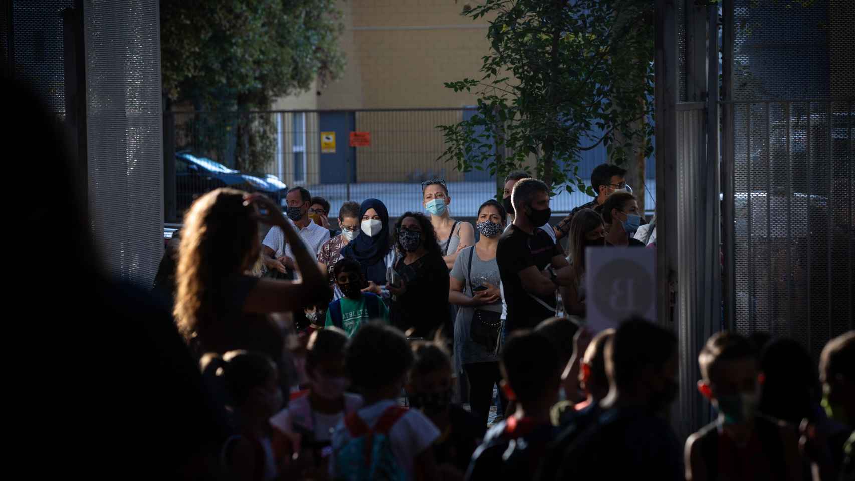 Padres y alumnos esperan en la puerta de un colegio protegidos contra el Covid con mascarillas / EP