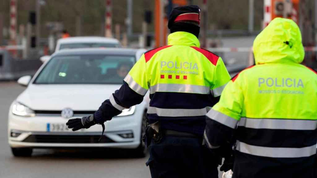 Un control policial de movilidad de los Mossos. Con las nuevas restricciones anunciadas, el confinamiento municipal pasará a ser comarcal el lunes / EFE