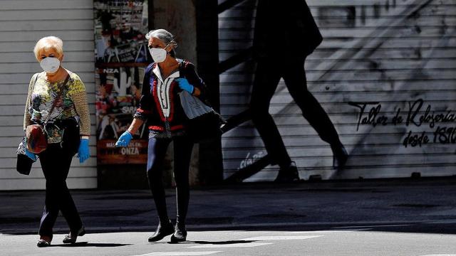 Dos mujeres salen a la calle protegidas con mascarillas / EFE