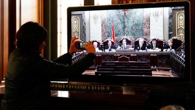 El tribunal del juicio del procés, presidido por Manuel Marchena, en un televisor del Tribunal Supremo / EFE