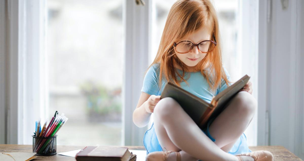 Una niña leyendo un libro / PEXELS