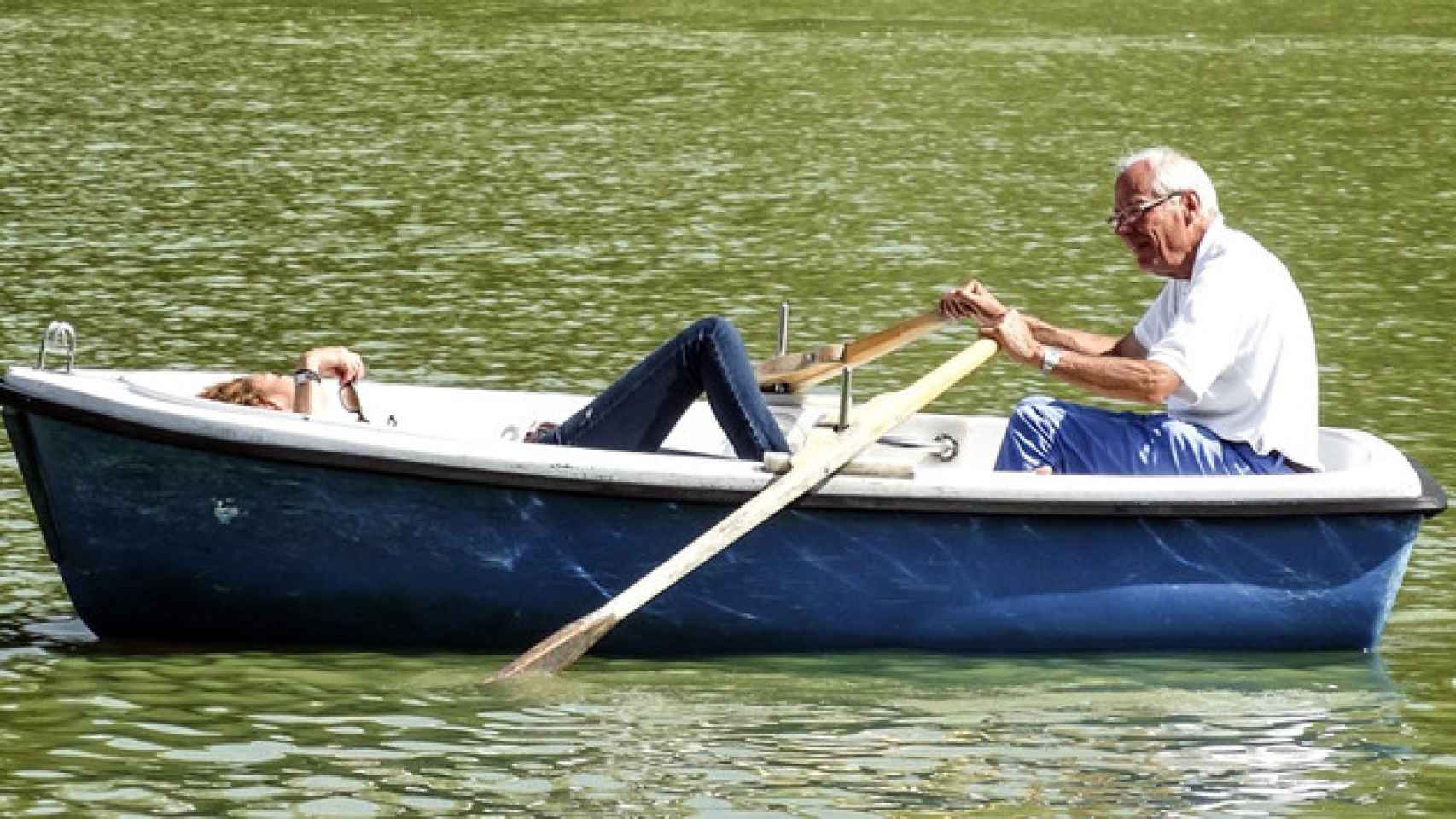 Un jubilado rema en una pequeña barca en un estanque