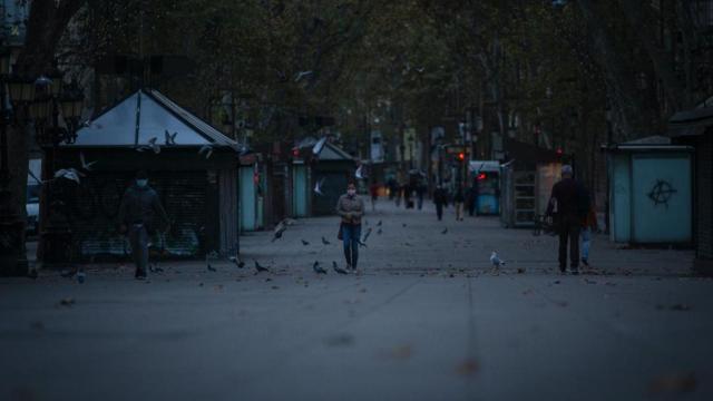 Una mujer camina por Las Ramblas tras el primer toque de queda desde las 22 hasta las 6 horas / DAVID ZORRAKINO