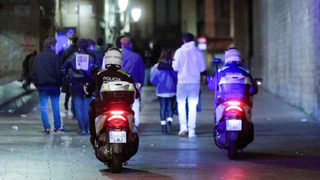 Agentes de la Guardia Urbana de Barcelona siguen a un grupo de personas que transita durante el toque de queda esta Nochevieja /  EFE - QUIQUE GARCÍA