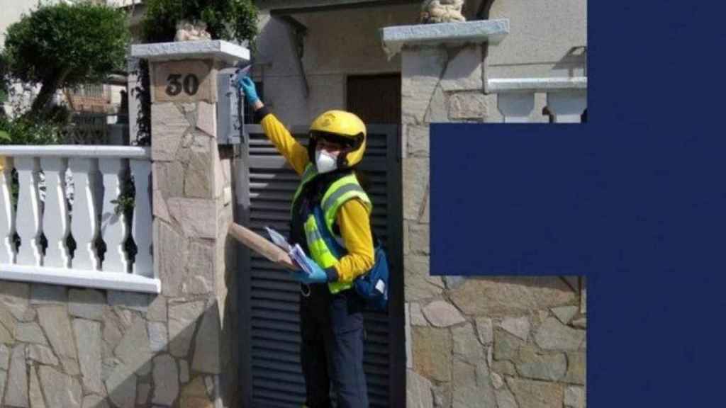 Una empleada de Correos entrega una carta en un domicilio / CORREOS