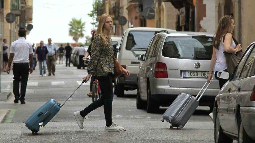 Dos turistas se dirigen a un piso turístico en el barrio de la Barceloneta, en una imagen de archivo / EFE