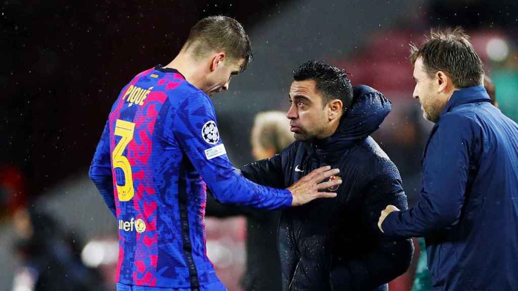 Gerard Piqué y Xavi Hernández hablan durante un partido de la Champions League / EFE