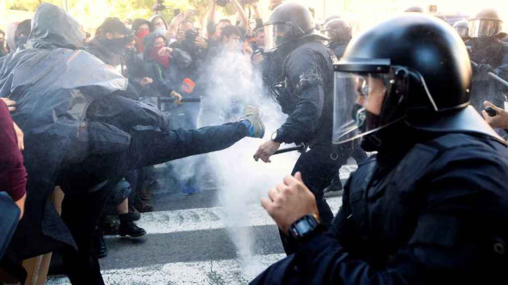 Los CDR lanzan harina contra los Mossos d'Esquadra en la manifestación del pasado sábado / EFE