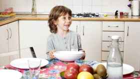 Un niño que sufre pobreza infantil desayuna en la cocina de su casa / EP