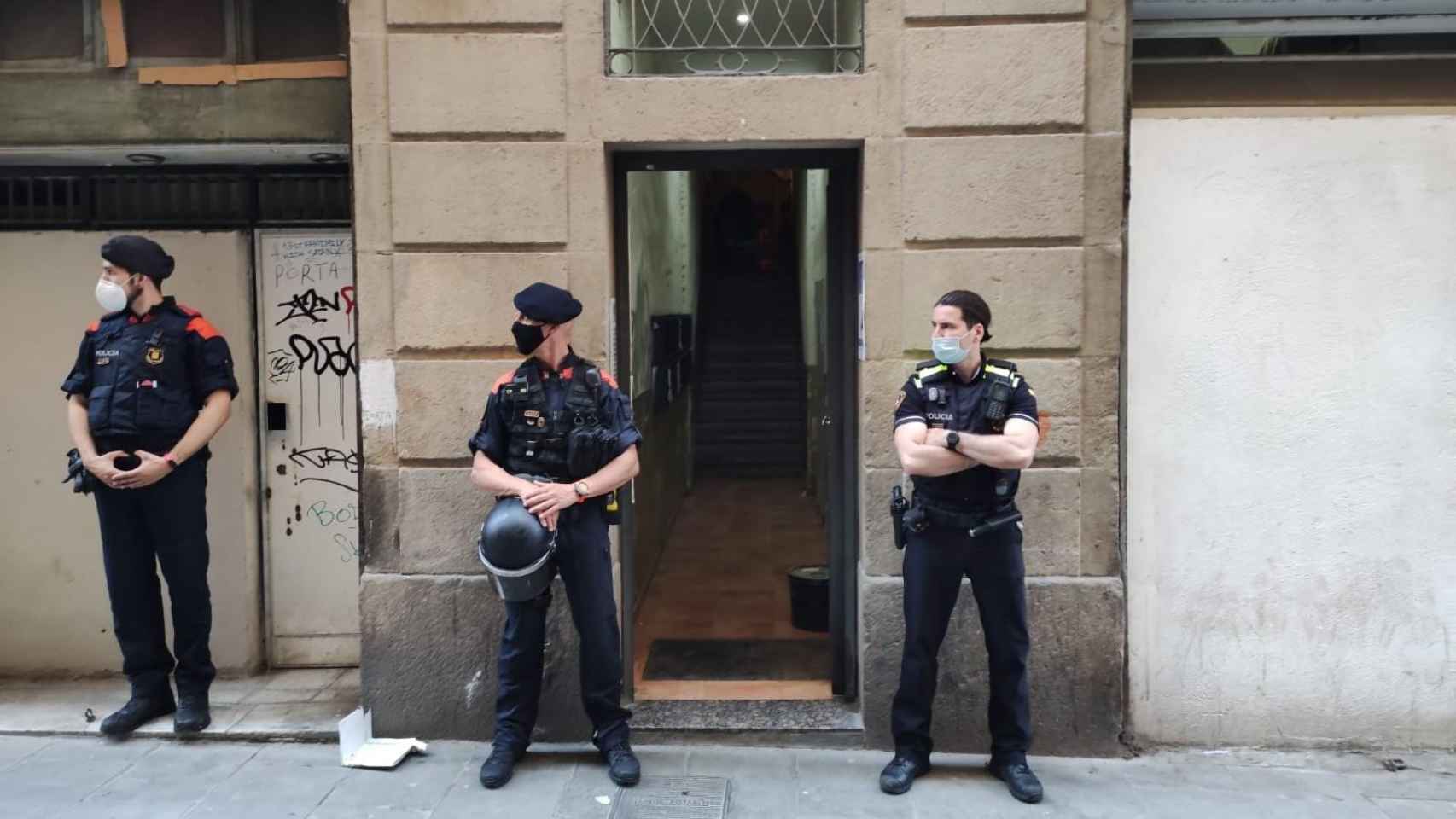 Operación conjunta entre Mossos d'Esquadra y Guardia Urbana, que vigilan la entrada durante el registro al piso okupado / MOSSOS