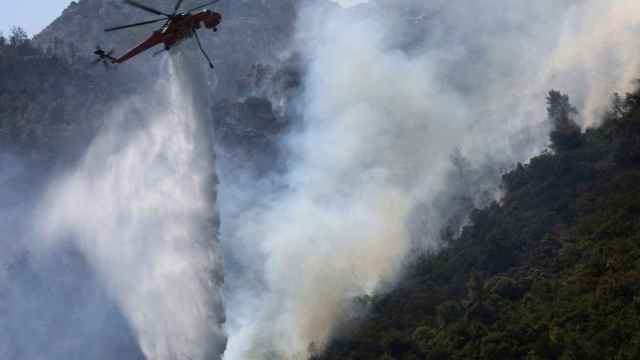 Un helicóptero intentando apagar uno de los incendios declarados en Grecia / EFE - EPA - ALEXANDER BELTES