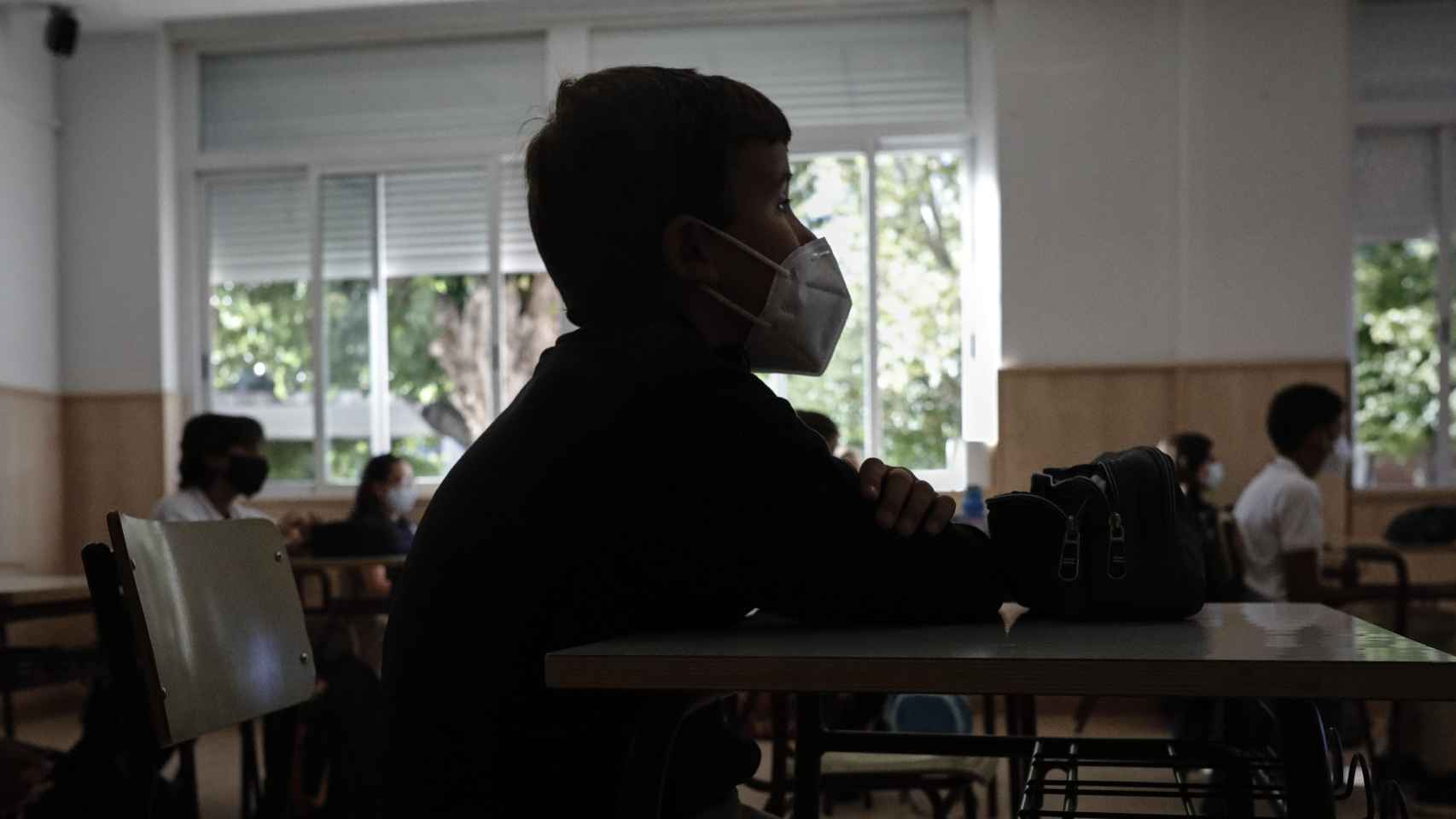 Un niño con mascarilla en un aula con las ventanas abiertas / EP