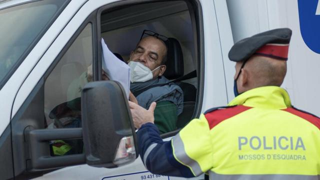 Un Mossos pide la documentación a un conductor para comprobar el motivo de su desplazamiento / GLORIA SÁNCHEZ