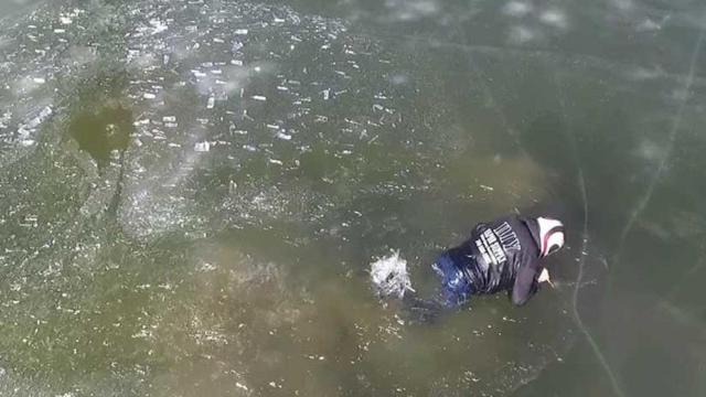 El hombre intenta salir del lago congelado en el que se ha hundido