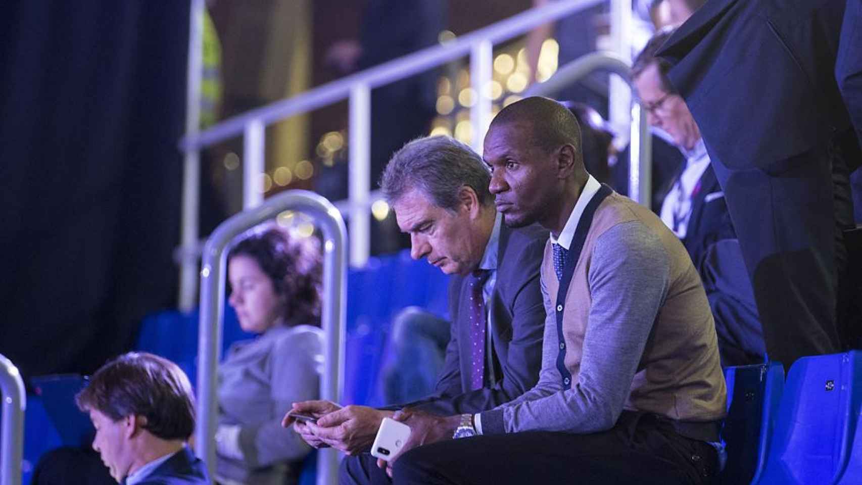 Pep Segura y Eric Abidal observando a un jugador en un partido de fútbol / EFE