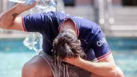 Un joven se tira una botella de agua por encima