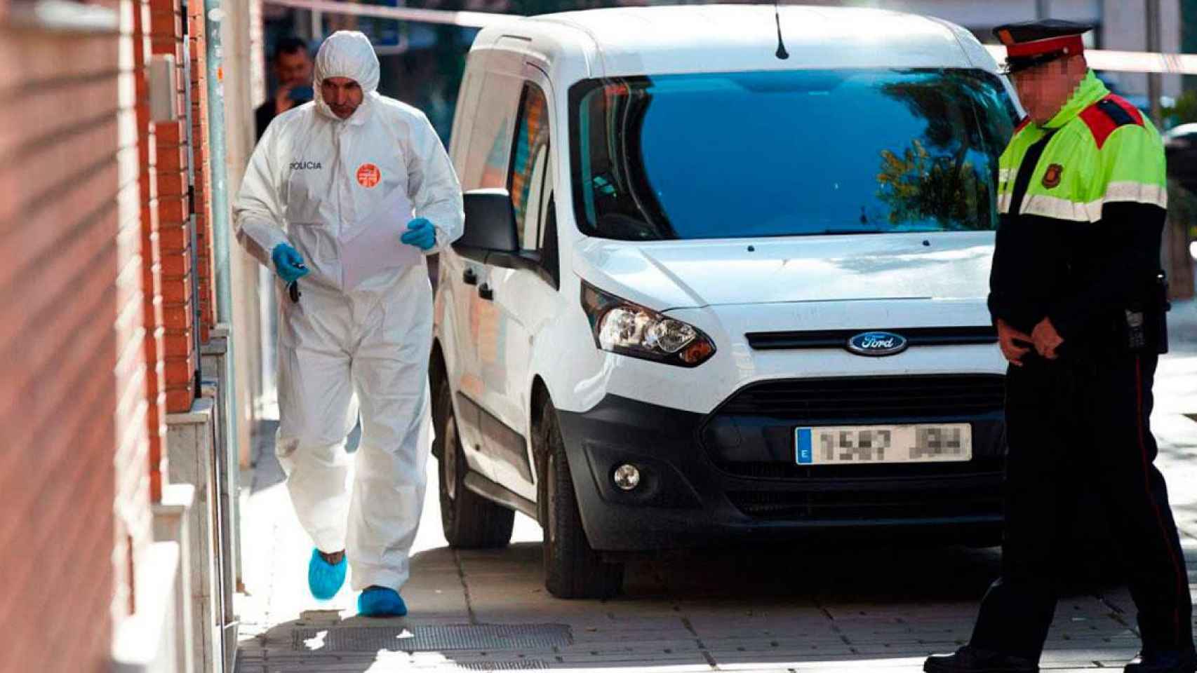 Agentes de policía frente al domicilio donde se cometió el crimen en Esplugues / EFE