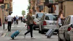 Dos turistas caminan con maletas por el barrio de la Barceloneta / EFE