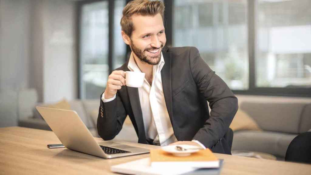 Empresario sonriente frente a un ordenador