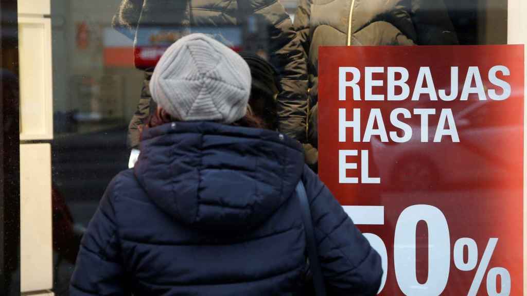 Una mujer delante de un escaparate en rebajas / EFE