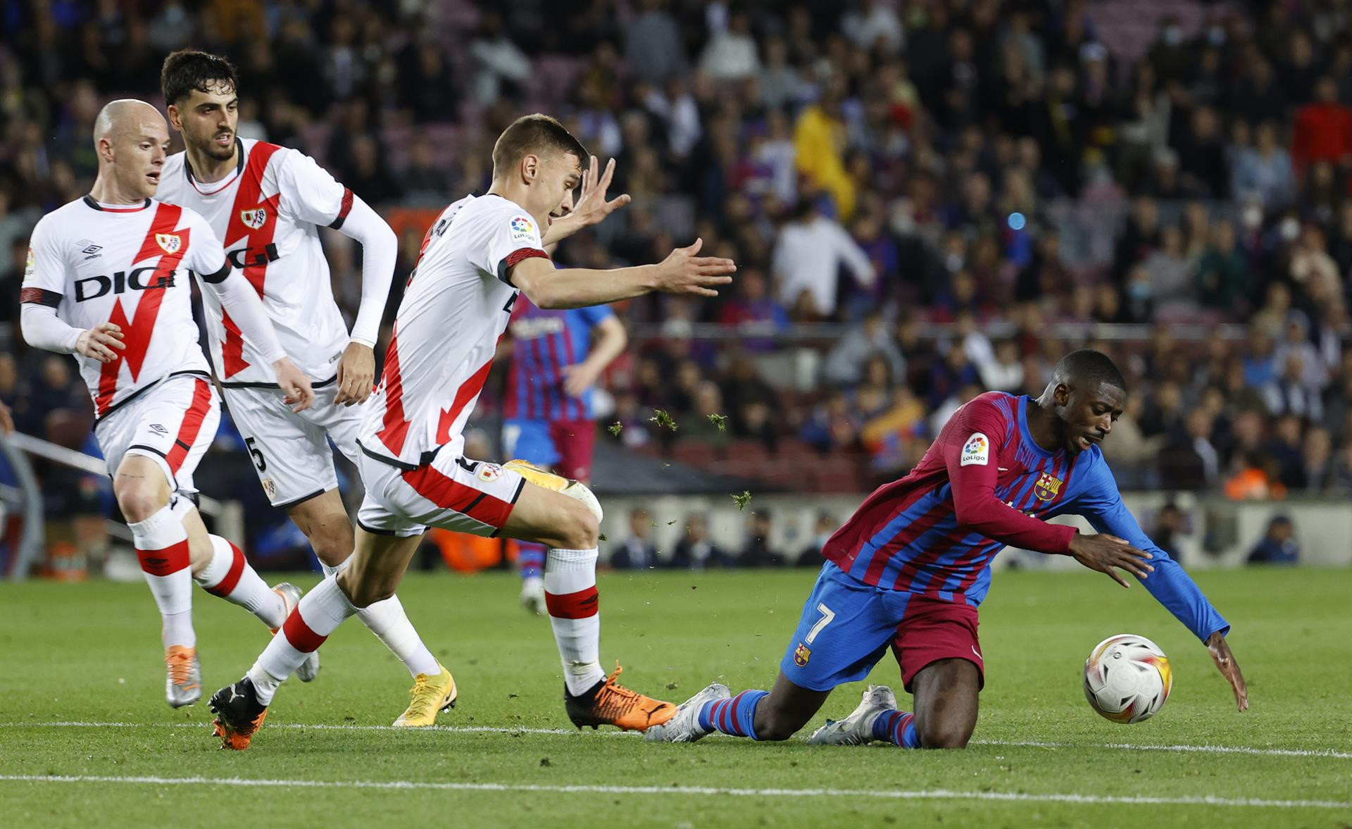 Dembelé, en el suelo, rodeado de futbolistas del Rayo / EFE