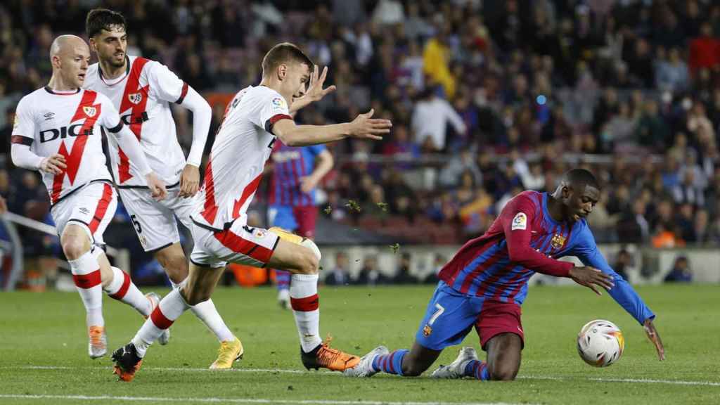 Dembelé, en el suelo, rodeado de futbolistas del Rayo / EFE