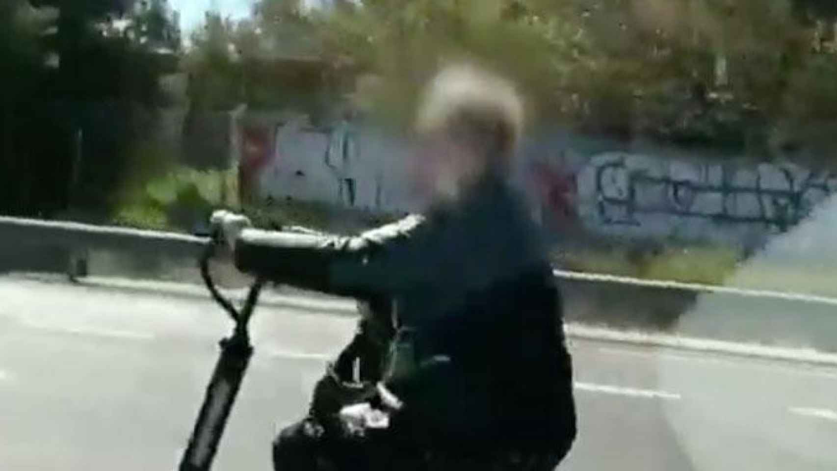 Una mujer conduce un patinete eléctrico por una autovía de cinco carriles / CG