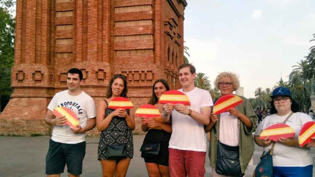 Varias personas sujetan abanicos decorados con los colores de la bandera española / ESPAÑOLES DE A PIE