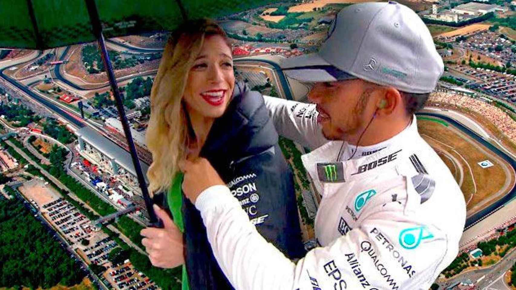 Hamilton abrigando a una de las 'paragüeras', con el fondo el Circuito de Cataluña / FOTOMONTAJE DE CG