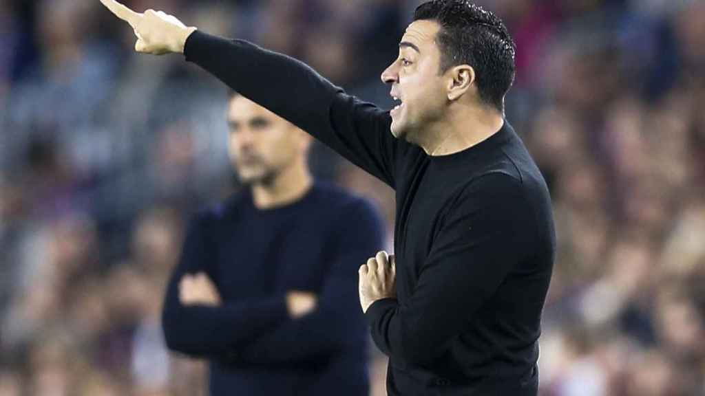 Xavi da instrucciones a sus jugadores con Michel al fondo / EFE