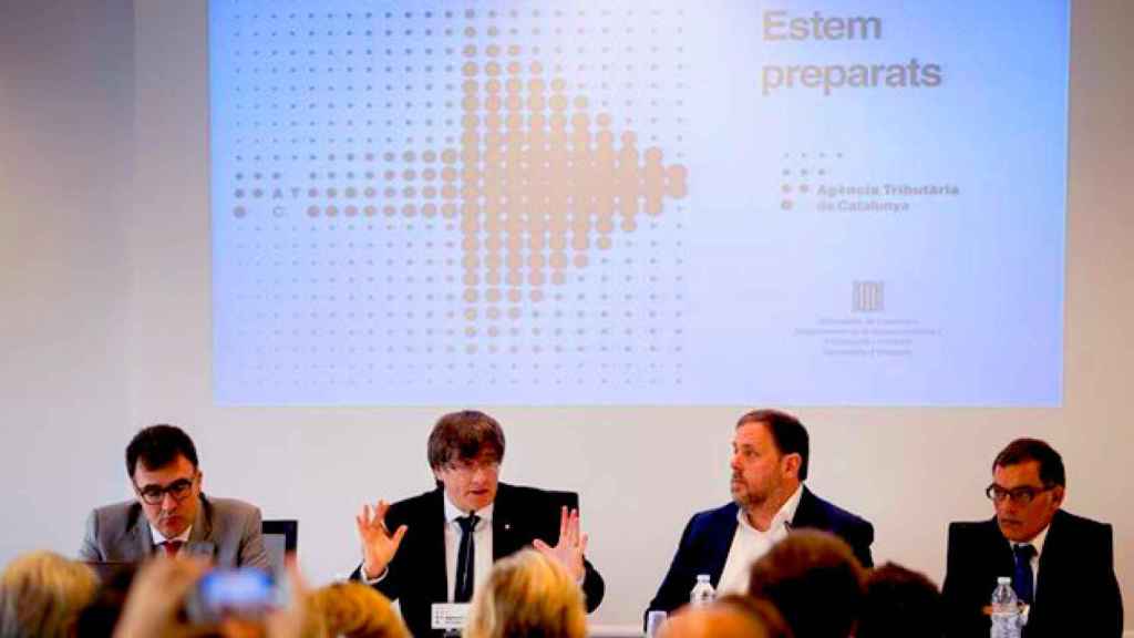 El expresidente Carles Puigdemont, y el vicepresidente Oriol Junqueras, durante la presenteación en rueda de prensa de la culminación del despliegue de la hacienda catalana / EFE