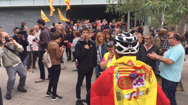 Un vecino ataviado con la bandera nacional discute con un independentista ante el Ayuntamiento de Badalona / CG