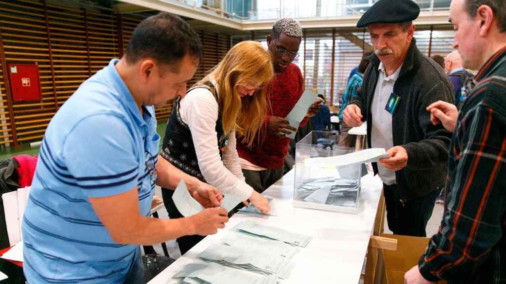 Varias personas participan en el recuento de las elecciones del 26M en una mesa electoral de Vitoria / EFE