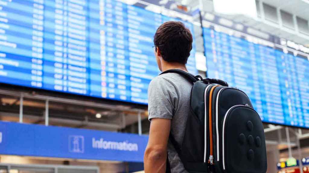 Un joven revisa la pantalla de un aeropuerto, en referencia a los jóvenes que marchan de España en busca de empleo / CG