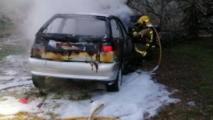 Un bombero apaga el fuego de un coche aparcado a las afueras de Roquetes (Tarragona) / BOMBERS