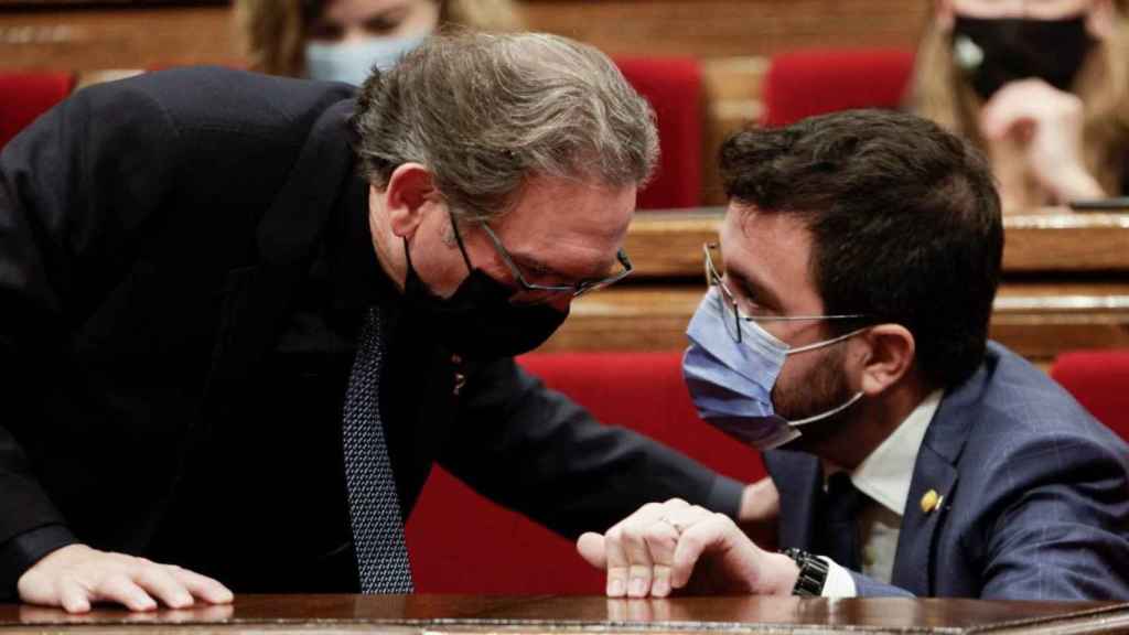 El consejero de Economía, Jaume Giró (JxCat), conversa con el presidente de la Generalitat, Pere Aragonès (ERC), en el Parlament / EFE