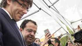 El presidente de la Generalitat, Carles Puigdemont, visita la caseta del Pacto Nacional por el Referéndum, donde ha coincidido con el coordinador general de la entidad, Joan Ignasi Elena