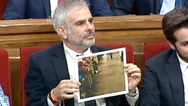 El portavoz de Ciudadanos, Carlos Carrizosa, muestra una foto de niños de la cola en el Parlamento catalán / CG