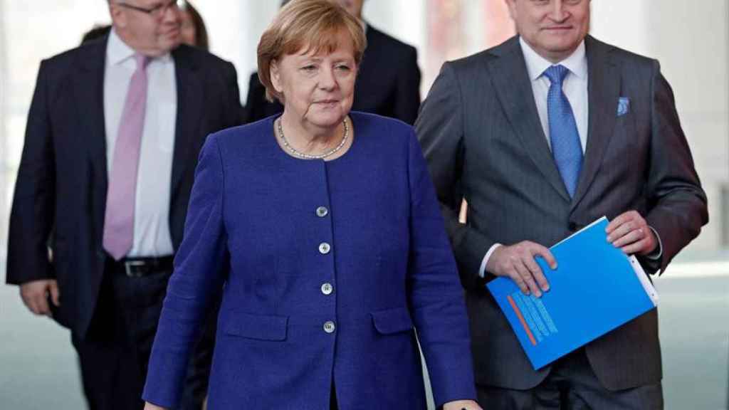 La canciller alemana, Angela Merkel, acompañada por el presidente del Consejo de Expertos, Christoph Schmidt, se dirige a presentar el informe de desarrollo económico / EFE