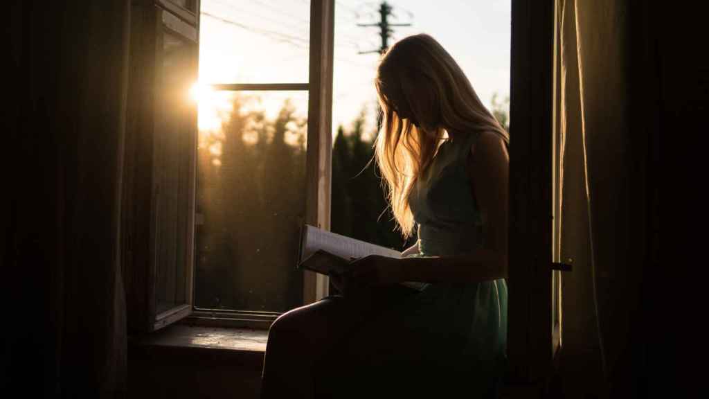 Una chica leyendo libros en los que aparece Barcelona/ UNSPLASH