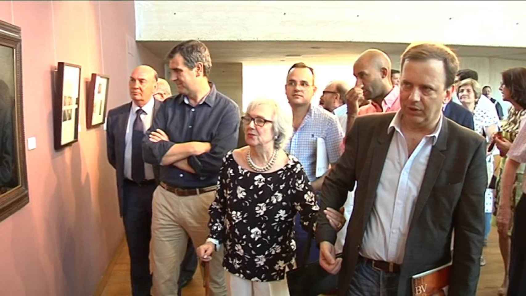 La viuda de Buero, Victoria Rodríguez, cogida a su hijo durante la inauguración de la exposición de homenaje montada por el Ayuntamiento de Guadalajara / YOUTUVE