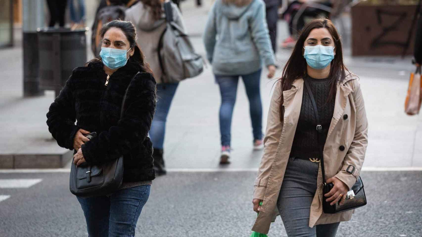 Personas con mascarillas por la calle / EP