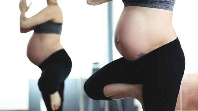 Una mujer embarazada, sin haber sufrido aborto en el primer trimestre, practica el yoga / Pexels