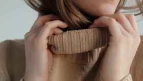 Mujer con un jersey beige de cuello alto / PEXELS