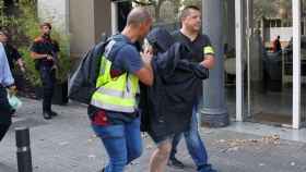 Mossos d'Esquadra y Policía Nacional custodian a una de las personas detenidas hoy en una operación en Barcelona contra el crimen organizado.