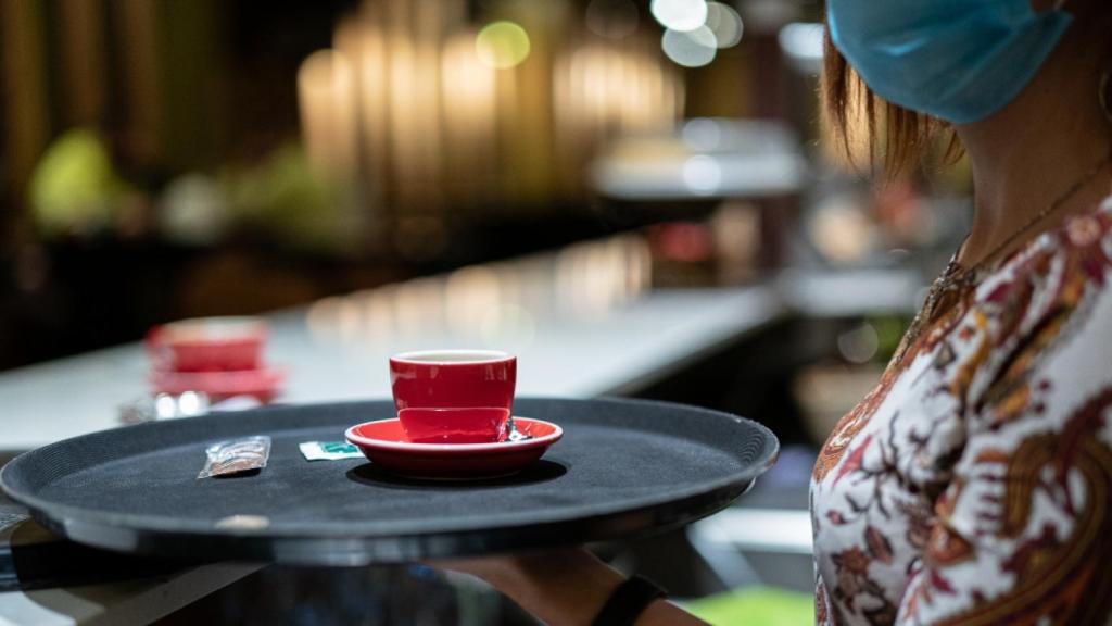 Una trabajadora lleva un café durante una jornada laboral / EP