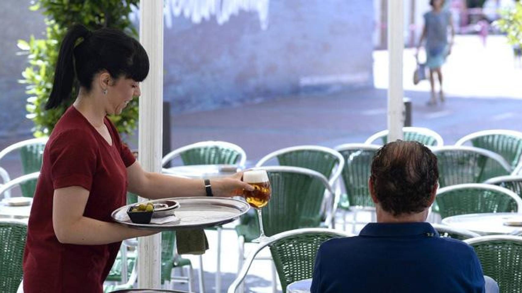 Una trabajadora sonríe mientras atiende a un cliente / EFE